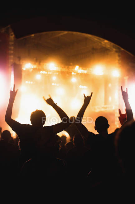 Pessoas anônimas de mãos erguidas e aplaudindo enquanto gastam tempo em incrível show de música — Fotografia de Stock