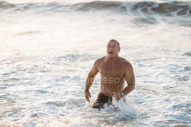 Strong old man going out from water — Stock Photo