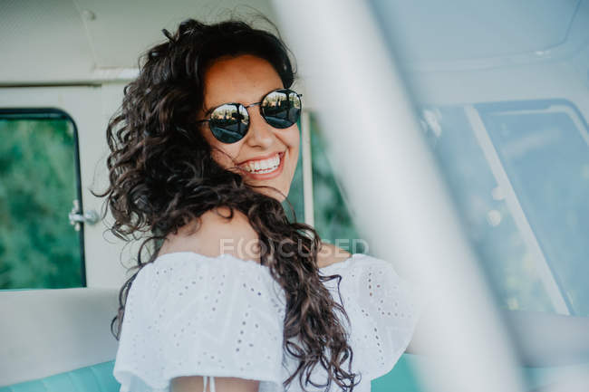 Портрет усміхненої брюнетки в сонцезахисних окулярах всередині машини — стокове фото
