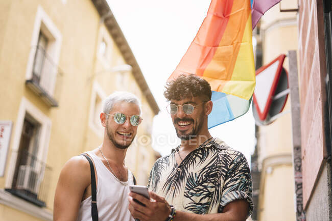 Pareja gay de chicos con Smatphone en la ciudad de Madrid - foto de stock