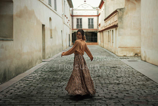 Atractiva mujer joven delgada en vestido posando en la calle - foto de stock