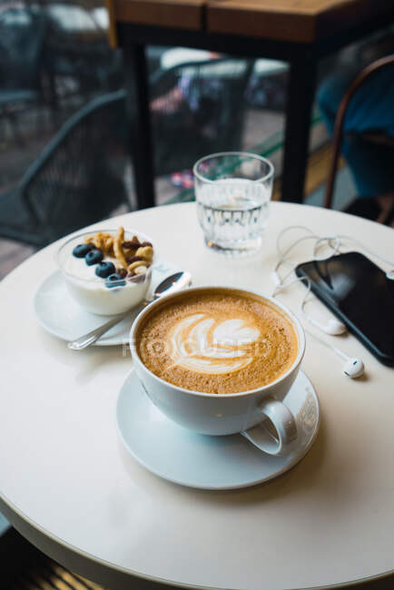 Чашка кави з мобільним телефоном — стокове фото