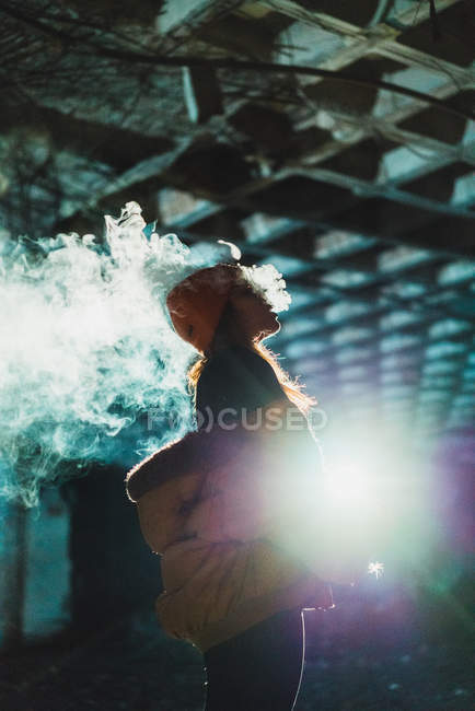 Femme vapotage dans un bâtiment abandonné — Photo de stock