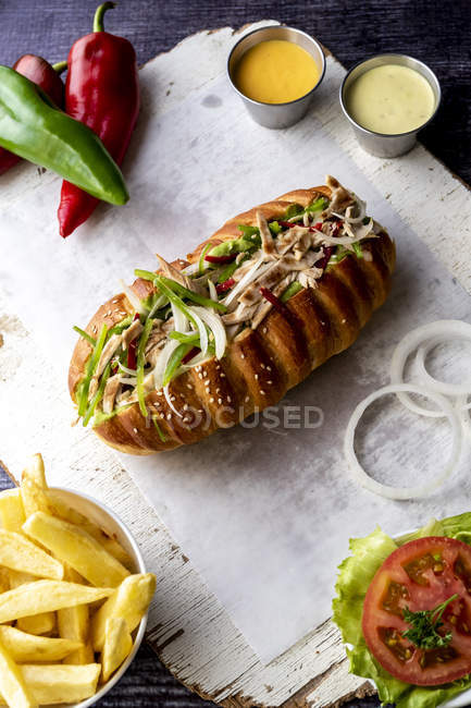 Big sandwich with vegetables and fried potatoes on paper napkin — Stock Photo