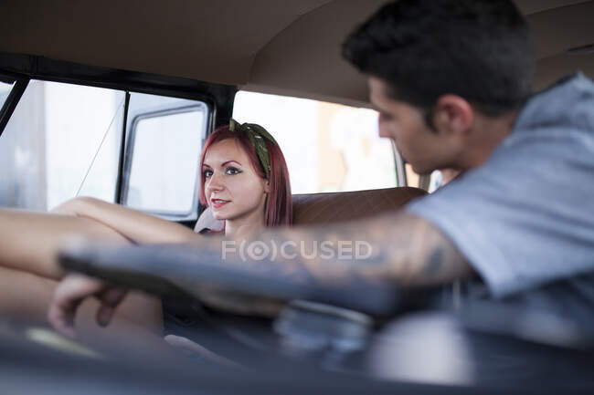 Schöne und junge Frau genießt die Fahrt in ihrem Oldtimer-Van mit ein paar Freunden — Stockfoto