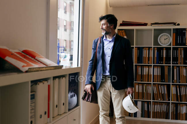 Jovem bonito olhando para longe no escritório — Fotografia de Stock