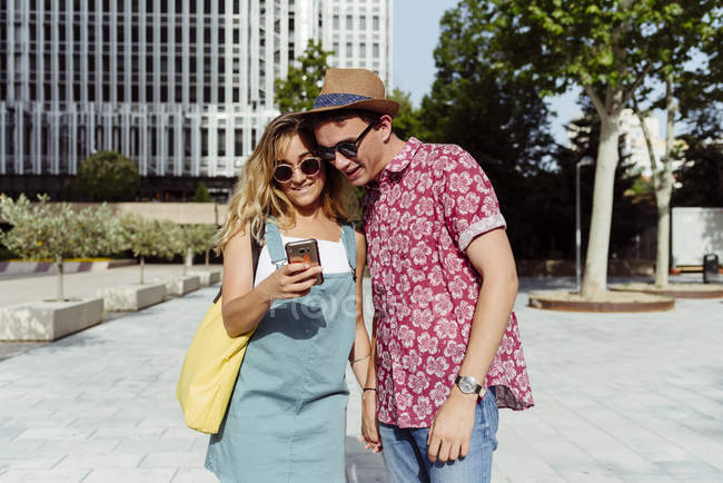 Couple browsing smartphone on street — Stock Photo