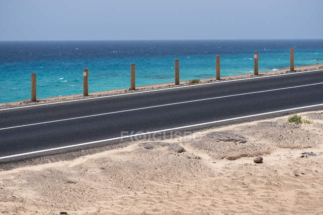 Strada e acqua blu dell'oceano sulle isole Canarie — Foto stock