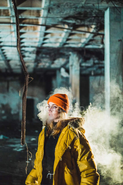 Mujer vapeando en edificio abandonado - foto de stock