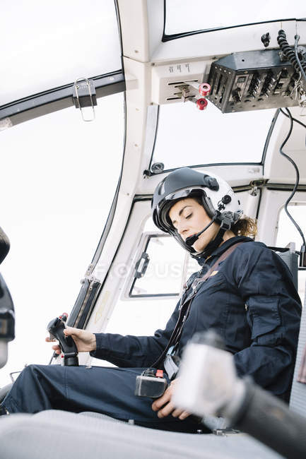 Женщина-пилот, сидящая и работающая в вертолете — стоковое фото