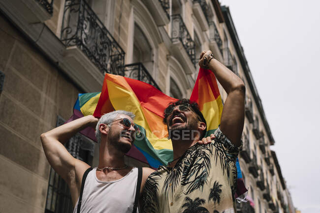 Couple garçons avec gay pride drapeau sur la rue de Madrid ville — Photo de stock