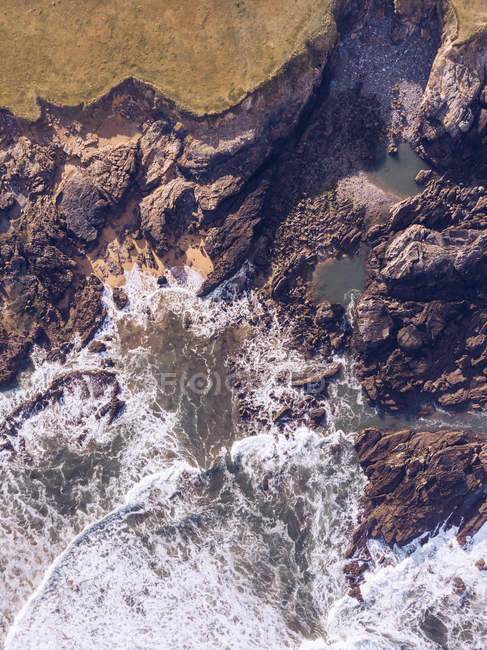 Vista incrível da água do mar salpicando perto de longo penhasco rochoso em dia nublado em Astúrias, Espanha — Fotografia de Stock