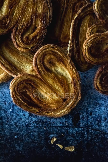 Pila de galletas de palmier en la pila sobre fondo azul malhumorado - foto de stock