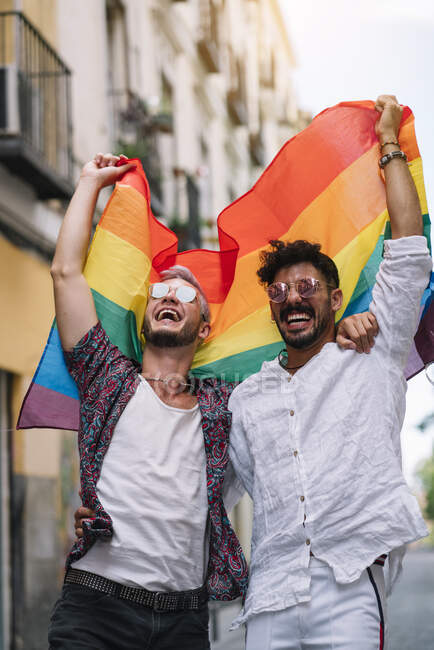 Casal meninos com gay orgulho bandeira no o rua de madri cidade — Fotografia de Stock