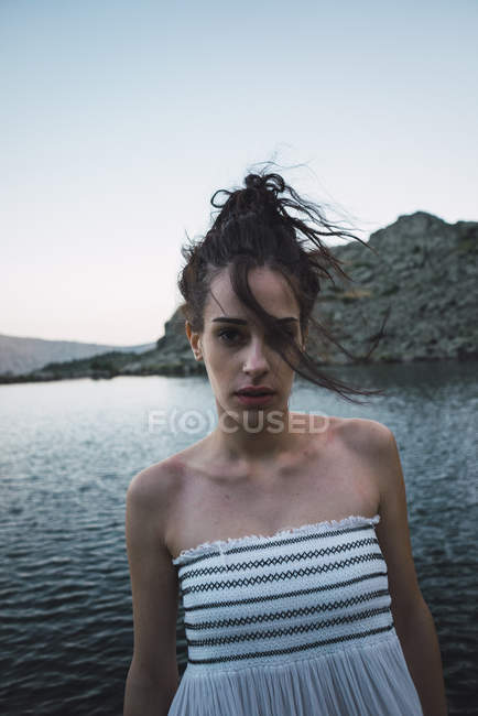 Портрет молодой женщины, стоящей рядом с волнистым озером — стоковое фото