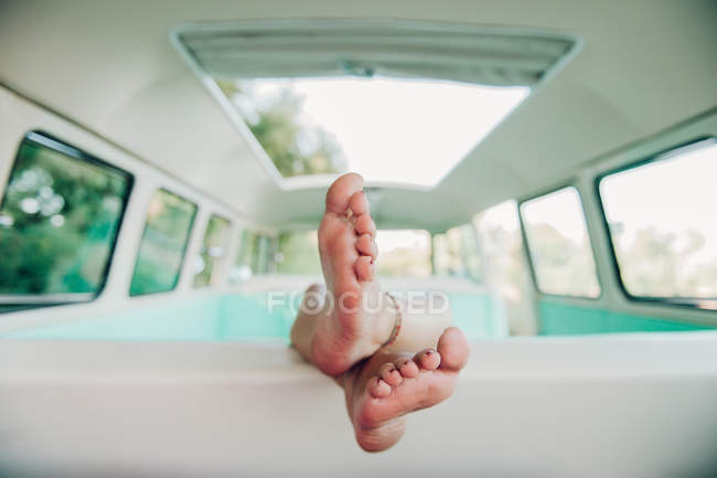 Primer plano de las piernas femeninas dentro de furgoneta retro - foto de stock