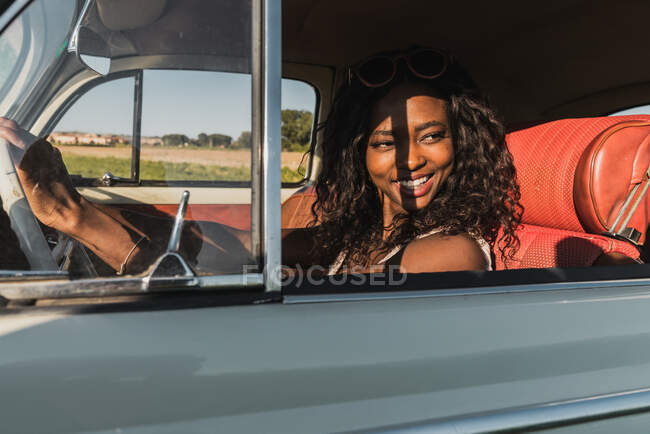 Bella sorridente donna africana americana guida auto — Foto stock