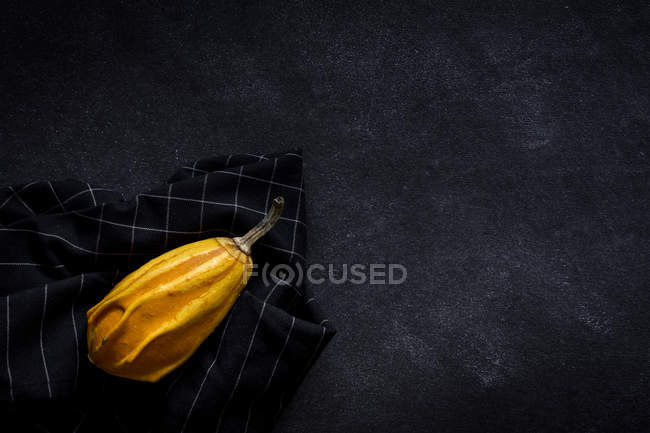 Halloween decoration of pumpkin on napkin on dark background with copy space. — Stock Photo