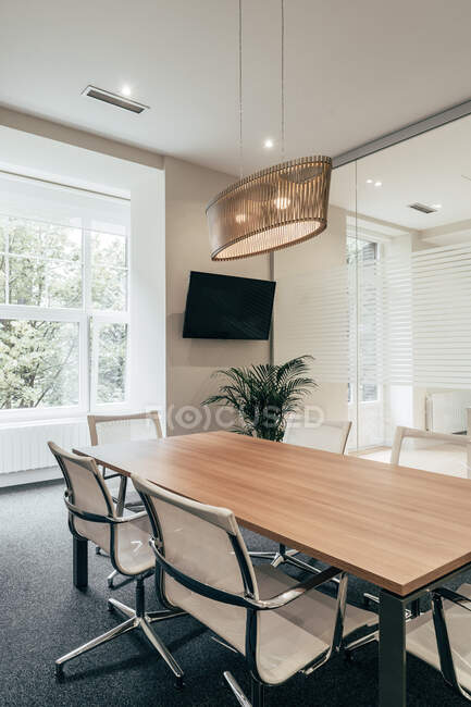 Langer Tisch und bequeme Stühle im stilvollen Besprechungsraum des modernen Büros — Stockfoto
