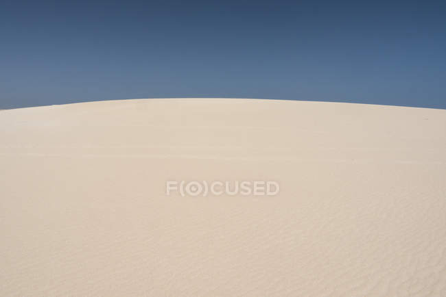 Sandige Hügel in trockener, wilder Wüste mit klarem blauen Himmel auf den Kanarischen Inseln — Stockfoto