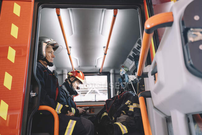 Vigili del fuoco che lavorano all'interno di un veicolo di emergenza. — Foto stock