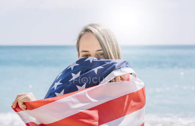 A girl posing on the beach with flag USA. — Stock Photo