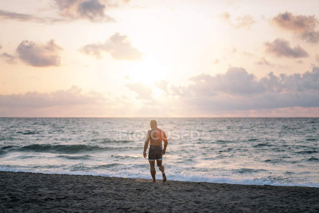 Strong old man posing on beach — Stock Photo