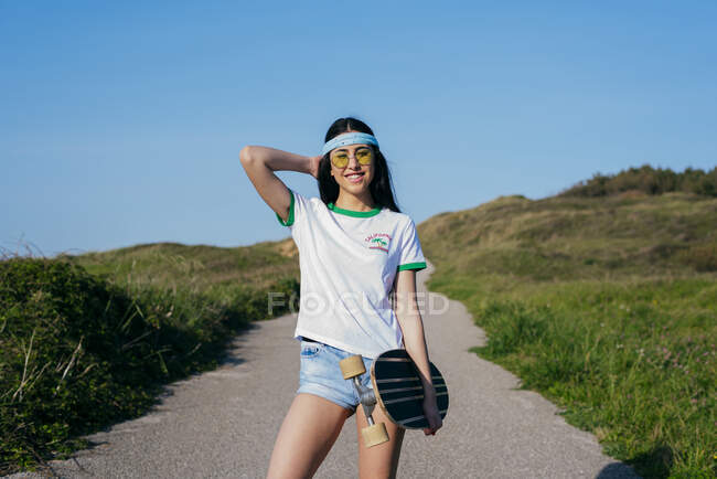 Élégant adolescent fille avec longue planche en été — Photo de stock