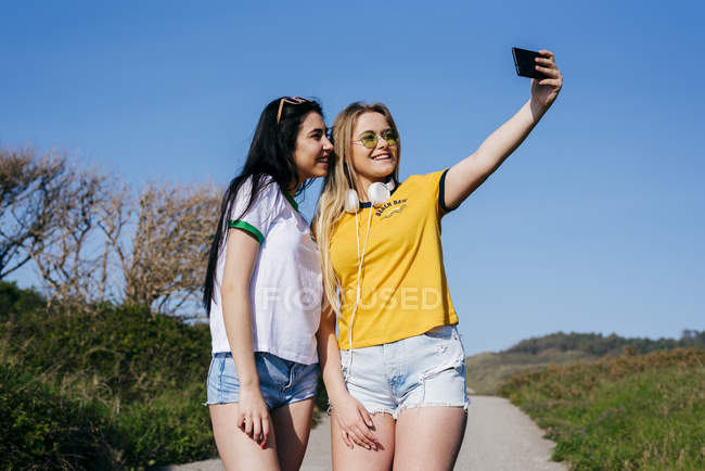 Chicas alegres tomando selfie afuera - foto de stock