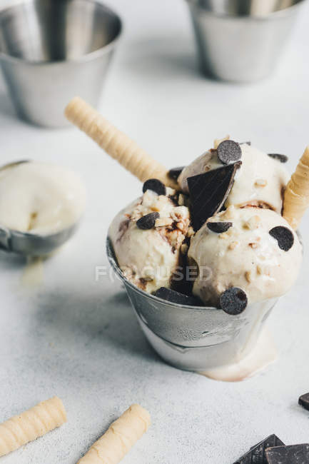 Gelato alla vaniglia con cioccolato e wafer su superficie bianca — Foto stock