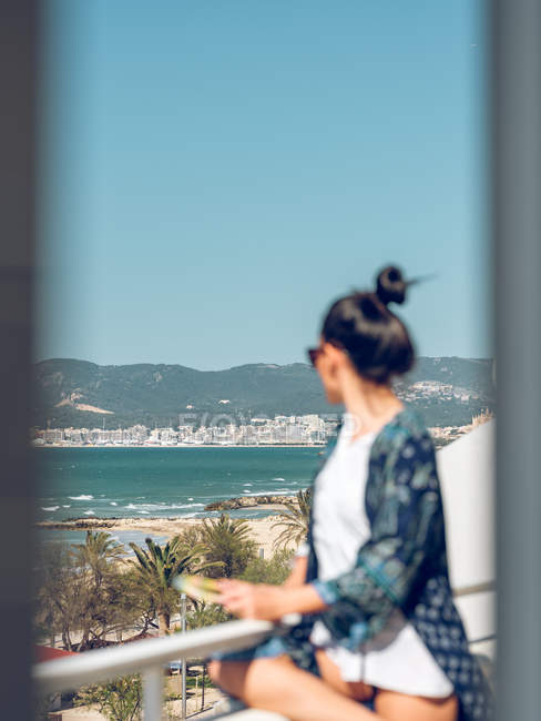 Жінка з книгою на балконі — стокове фото
