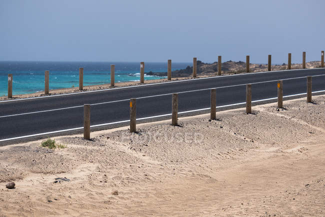 Camino a través del desierto y el agua del océano en las islas Canarias - foto de stock