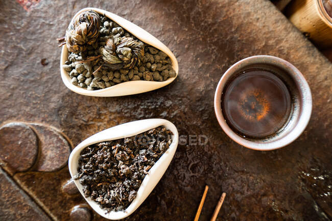 De dessus théière et feuilles de thé sèches sur la table orientale pour la cérémonie traditionnelle — Photo de stock