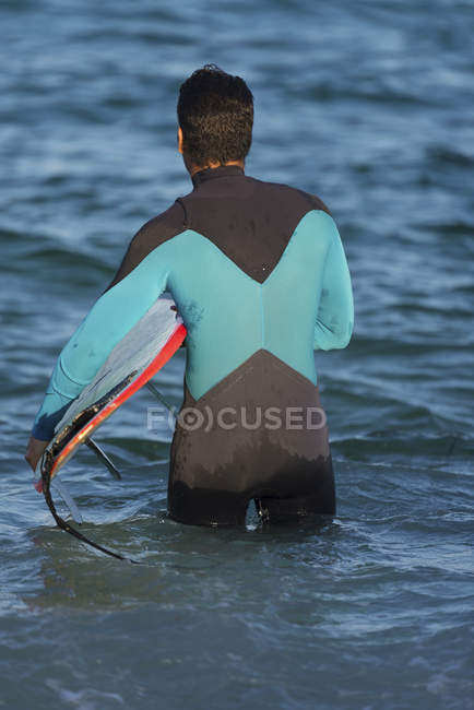 Surfista masculino surfando com prancha de surf no mar em um dia ensolarado — Fotografia de Stock