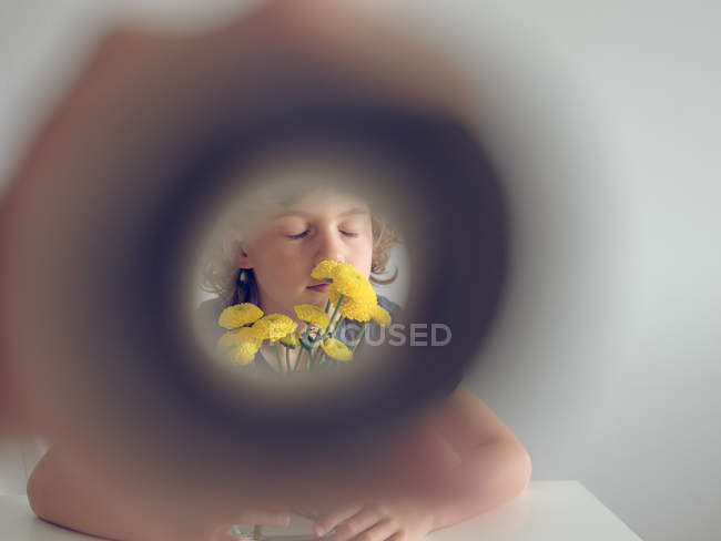 Boy and dandelions through paper tube — Stock Photo