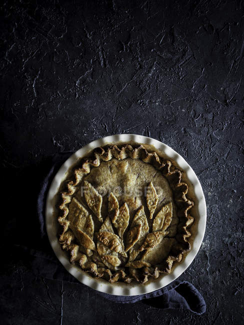 Appetizing fresh baked pie on dark rough background — Stock Photo