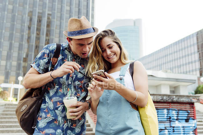 Couple naviguant smartphone dans la rue — Photo de stock