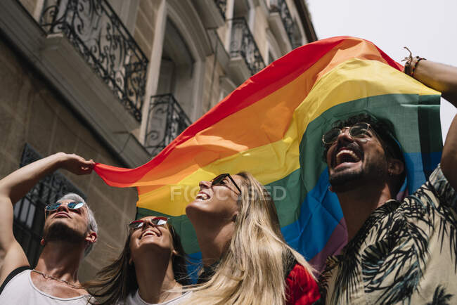 Grupo de amigos com uma bandeira de orgulho gay na cidade de Madrid — Fotografia de Stock