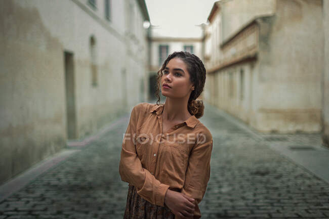 Приваблива струнка молода жінка в одязі позує на вулиці — стокове фото