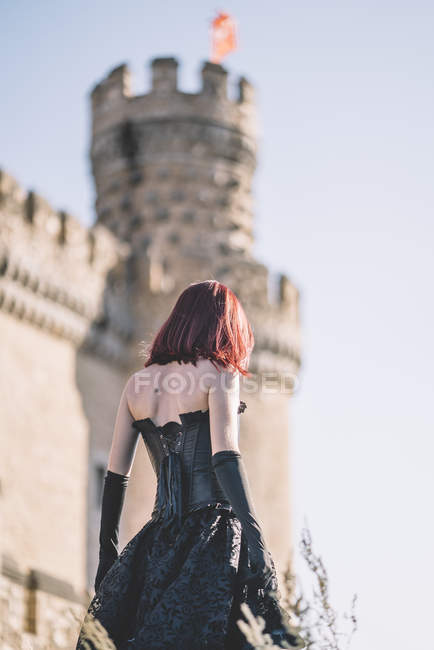 Red haired medieval girl poses together castle — Stock Photo