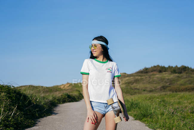 Стильна дівчина-підліток з довгою дошкою в літній час — стокове фото