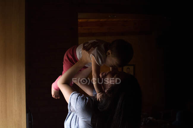 Mulher na cozinha brincando com bebê — Fotografia de Stock