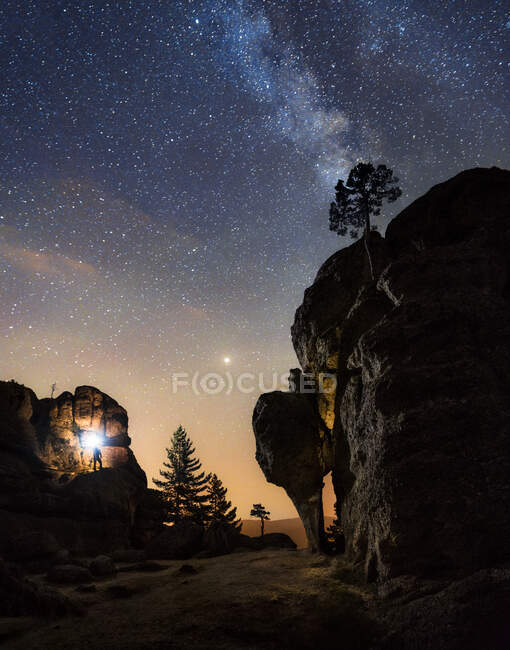 Silhouette di un uomo nella notte in cima alla montagna con una torcia sotto un incredibile la via lattea. Soria, Spagna — Foto stock