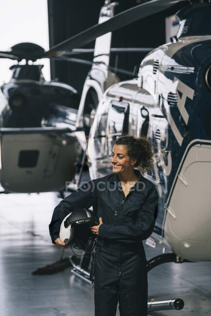 Pilotin posiert mit Hubschrauber und Helm — Stockfoto
