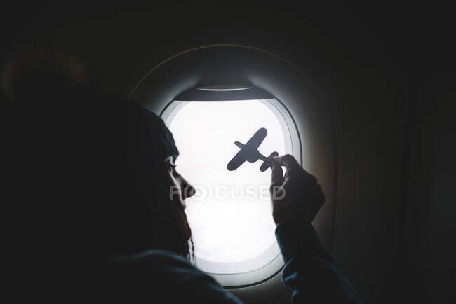 Frau zeigt Flugzeugmodell im Fenster. — Stockfoto