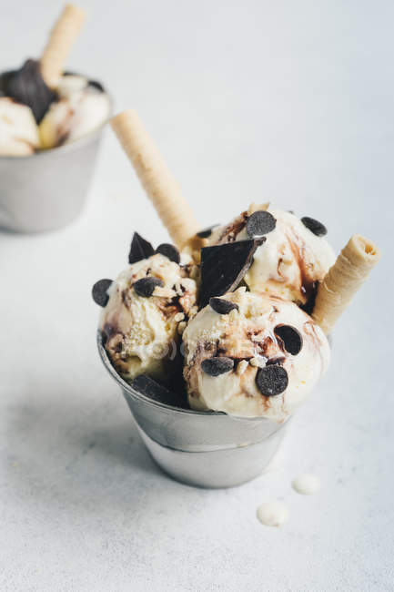 Ванильное мороженое с шоколадом и вафлями на белой поверхности — стоковое фото