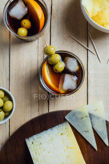 Cocktails et snacks servis sur table en bois — Photo de stock