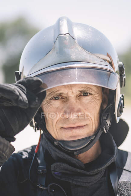 Bombero posa con casco mirando a la cámara. - foto de stock
