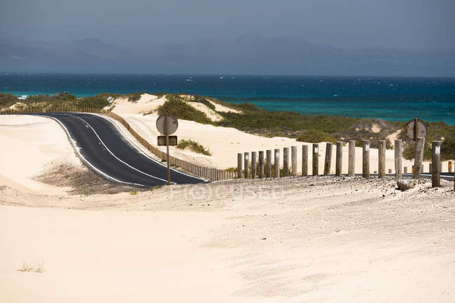 Route à travers le désert et l'eau de mer sur les îles Canaries — Photo de stock