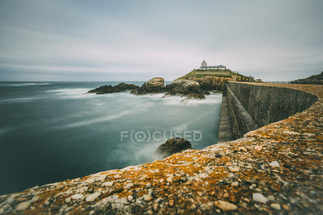 Cantabrian sea coast with lighthouse in overcast, Spain — Stock Photo